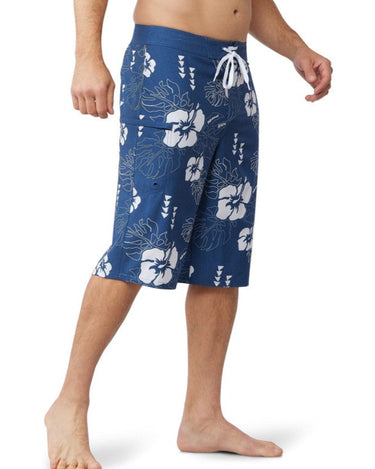 Man wearing the 24 inch blue hawaiian floral boardshorts from the side