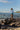 Woman on rocks holding fishing pole wearing sun shirt and boardshorts