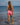Woman wading in the ocean wearing maui rippers tangerine lemonade shorts 